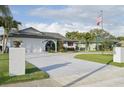 Attractive single-story home with a wide driveway and vibrant landscaping, featuring an American flag at 1300 Lucaya Ave, Venice, FL 34285