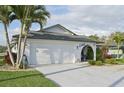 Bright single-story home with attached garage, lush lawn and tropical landscaping, showcasing curb appeal at 1300 Lucaya Ave, Venice, FL 34285