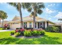Beautiful single-story home featuring a well-manicured lawn, vibrant flower beds, and a two-car garage at 1330 Berkshire Ct, Venice, FL 34292