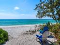 Relaxing beach scene with chairs, white sand, and clear turquoise water at 1604 Casey Key Rd, Nokomis, FL 34275