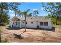 Charming white house with a blue front door and a well-maintained yard, surrounded by trees at 1871 Bridge St, Englewood, FL 34223