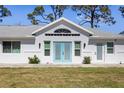 A well-maintained home with a modern front exterior, blue double doors, and manicured lawn at 1871 Bridge St, Englewood, FL 34223