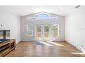 Spacious living room featuring light-colored wood floors, French doors to backyard, and modern fixtures at 1871 Bridge St, Englewood, FL 34223