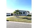 Cozy gray home surrounded by manicured lawn and picturesque palm trees at 199 Palm Harbor Dr, North Port, FL 34287