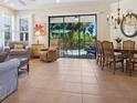Spacious living area with tile flooring, comfortable seating, and access to a screened-in lanai at 20390 Cavallo Ct, Venice, FL 34292