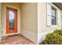 Close-up of a welcoming front door with decorative glass and sidelight, enhanced by manicured landscaping at 20925 Valore Ct, Venice, FL 34293