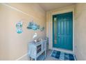 Inviting foyer with vibrant teal door, coastal decor, and stylish accents at 2172 Chenille Ct, Venice, FL 34292