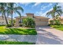 Charming single-story home with a lush tropical landscape, beautiful lawn, and a brick paver driveway at 2172 Chenille Ct, Venice, FL 34292