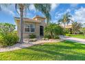 Charming home with mature tropical landscaping and a brick paver walkway leading to the entrance at 2172 Chenille Ct, Venice, FL 34292