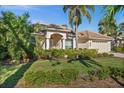 Inviting home exterior featuring manicured landscaping, a paver driveway, and a well-kept lawn at 2175 Calusa Lakes Blvd, Nokomis, FL 34275
