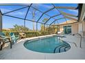 Screened-in pool area with clear blue water, seating, and views of the surrounding landscape at 2175 Calusa Lakes Blvd, Nokomis, FL 34275
