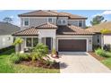 Beautiful two-story home with a tile roof, landscaped yard, and a welcoming front porch with seating at 228 Caserta Ct, North Venice, FL 34275