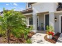 Welcoming home entrance with manicured landscaping and a cozy seating area on the covered front porch at 228 Caserta Ct, North Venice, FL 34275