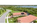 Birds eye view of a home featuring a tile roof, pool, solar panels, and well-manicured lawn at 24036 Spartina Dr, Venice, FL 34293
