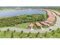 Panoramic aerial view of a neighborhood near a lake with single-Gathering homes and lush greenery at 24036 Spartina Dr, Venice, FL 34293