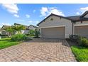Brick paved driveway leading to a home with well-manicured landscaping at 27440 Janzen Ct, Englewood, FL 34223