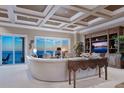 Bright living room with ocean view through sliding doors, coffered ceiling, and stylish décor for comfort at 2821 Casey Key Rd, Nokomis, FL 34275