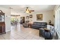 Bright and airy living room with white tile floors, ceiling fan, and a comfortable seating area at 2983 Greendale Rd, North Port, FL 34287