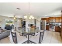 Open-concept living area featuring kitchen and dining spaces with tile flooring and a ceiling fan at 2983 Greendale Rd, North Port, FL 34287