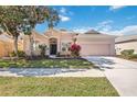 Charming single-story home with a well-manicured lawn and a spacious two-car garage on a sunny day at 312 Londonderry Dr, Sarasota, FL 34240