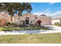 Charming single-story home with a well-manicured lawn and a spacious two-car garage on a sunny day at 312 Londonderry Dr, Sarasota, FL 34240