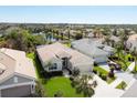 Aerial view of a charming home with a well-manicured lawn, complemented by a lake view at 339 Marsh Creek Rd, Venice, FL 34292