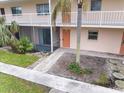 Ground floor condo unit featuring a private patio and manicured landscaping at 400 Base E Ave # 213, Venice, FL 34285