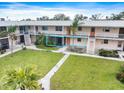 Two-story condo building showcasing well-maintained landscaping and walkways at 400 Base E Ave # 213, Venice, FL 34285