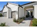 Beautiful home exterior with a three-car garage, stone driveway, and manicured landscaping at 448 Bocelli Dr, Nokomis, FL 34275
