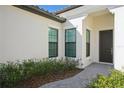 Inviting front entrance featuring a dark door framed by windows and vibrant landscaping at 448 Bocelli Dr, Nokomis, FL 34275