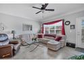 Bright living room featuring neutral walls, tile floors, modern ceiling fan, and comfortable furniture at 4802 51St W St # 1816, Bradenton, FL 34210