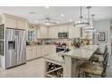 Well-appointed kitchen with stainless steel appliances, granite countertops, wine rack, and modern lighting fixtures at 6216 Pecan Rd, Venice, FL 34293