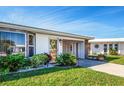 Inviting home featuring lush landscaping, decorative stone accents, and a covered carport at 72 Circlewood Dr # A2-7, Venice, FL 34293
