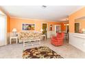 Inviting living room featuring tile flooring, coral walls, and floral-patterned furnishings at 72 Circlewood Dr # A2-7, Venice, FL 34293