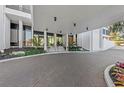 Inviting building entrance with a covered drive-through, lush landscaping, and a clean modern design at 770 S Palm Ave # 404, Sarasota, FL 34236