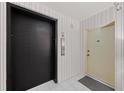 Condo elevator bank with a black elevator door and white door for unit access at 770 S Palm Ave # 404, Sarasota, FL 34236