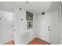 Hallway with tile flooring, neutral paint, artwork, and an access door to the unit at 770 S Palm Ave # 404, Sarasota, FL 34236