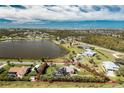 An aerial view of the property featuring a large in-ground pool, solar panels and waterfront views at 8170 Casa De Meadows Dr, Englewood, FL 34224