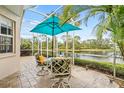 Screened in patio featuring outdoor seating under an umbrella with a view of the pond at 902 Tartan Dr # 29, Venice, FL 34293