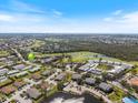 Aerial view of the condo community surrounded by lush greenery and a nearby golf course at 944 Capri Isles Blvd # 103, Venice, FL 34292
