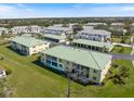 Aerial view of the condo building with a large grassy yard and ample parking at 944 Capri Isles Blvd # 103, Venice, FL 34292