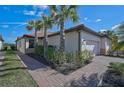 Charming single-story home featuring a well-kept lawn, neat landscaping, and a brick walkway at 9900 Haze Dr, Venice, FL 34292
