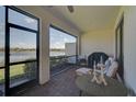 Relaxing screened-in patio with comfortable seating and a beautiful view of the lake at 9900 Haze Dr, Venice, FL 34292