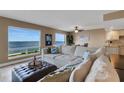 Spacious living room featuring calming paint colors, water views, and comfortable seating with accent pillows and ottoman at 1 Colony Point Dr # 11A, Punta Gorda, FL 33950