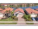 Beautiful aerial view of the home, showcasing its tile roof and the serene lake in the background at 10412 Crooked Creek Dr, Venice, FL 34293