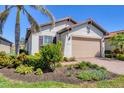 Inviting home featuring a well-manicured lawn, beautiful plants and a spacious brick driveway at 10412 Crooked Creek Dr, Venice, FL 34293