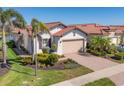 Lovely home exterior featuring a brick driveway, two car garage, and beautifully landscaped yard at 10412 Crooked Creek Dr, Venice, FL 34293