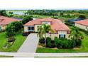 Single-Gathering home featuring tile roof, well-manicured lawn, and a spacious paver driveway near a lake at 10742 Ironbridge Dr, Venice, FL 34293