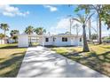 A lovely home with a long driveway leading to a covered carport, surrounded by lush landscaping at 1075 Falcon Rd, Venice, FL 34293