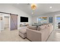 Bright living room features vaulted ceiling, large sectional sofa, a barn door, and access to the outdoor area at 1087 Piedmont Rd, Venice, FL 34293